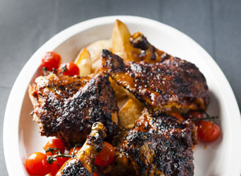 Peri-peri chicken with potato wedges and pan-fried tomatoes