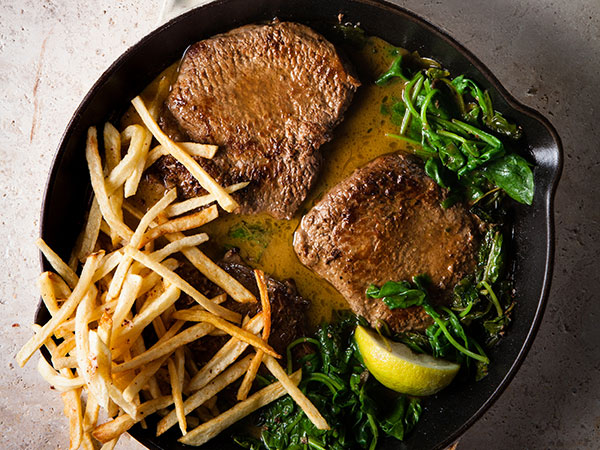 Steak with anchovy-spinach sauce and matchstick fries. Photo by Jan Ras.